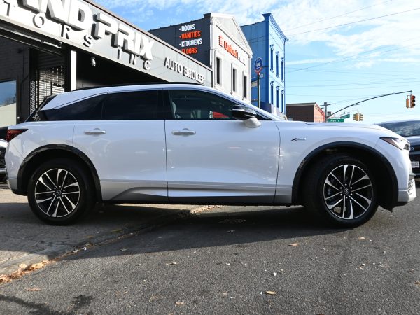 2024 Acura ZDX side profile under ambient urban lighting.