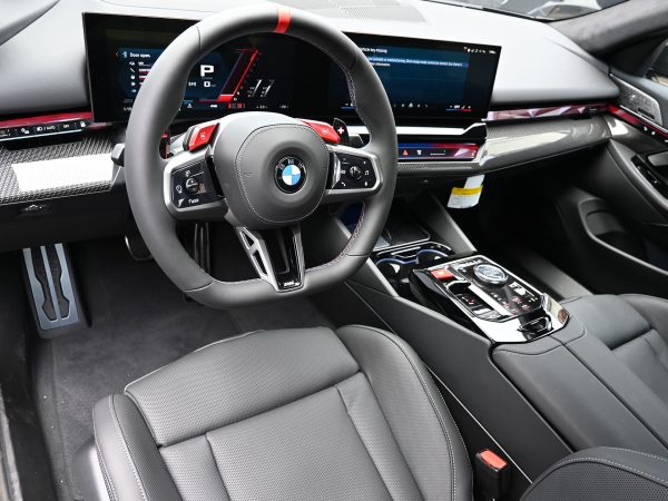 Close-up of the BMW M5 Hybrid’s illuminated M steering wheel controls.