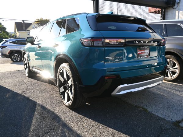 Side profile of the 2025 Honda Prologue parked in a modern urban setting